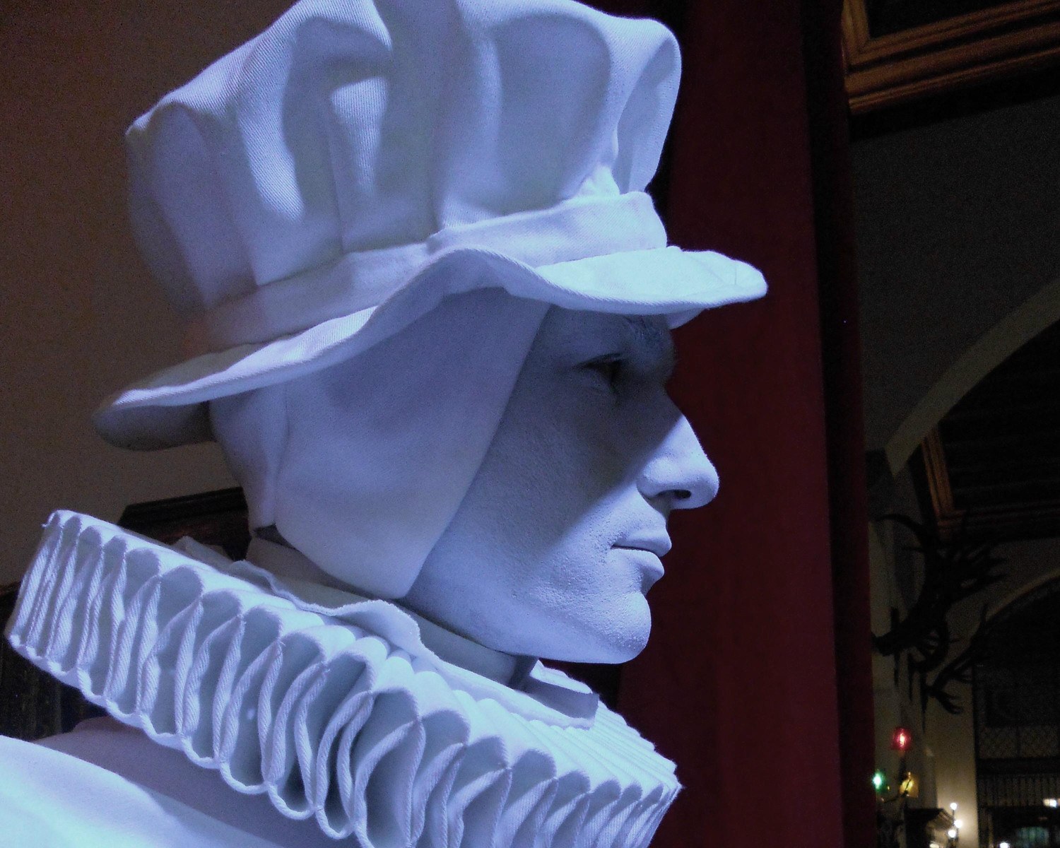 Statua vivente in costume barocco bianco in un interno storico